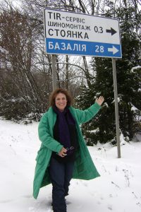 Zane Buzby standing at the sign with the name of her Grandparent's Town